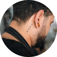 Detalle de tatuaje en cuello de barista mientras prepara café