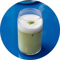 Matcha latte frío con espuma cremosa servido en vaso transparente
